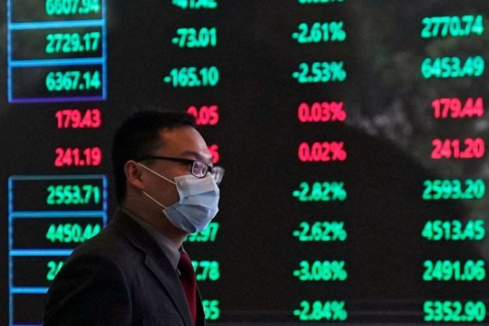 Homem usa máscara de proteção dentro da Bolsa de Valores de Xangai