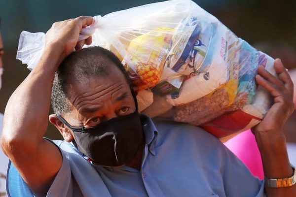 Morador de favela de SP recebe cesta básica doada durante a pandemia de Covid-19