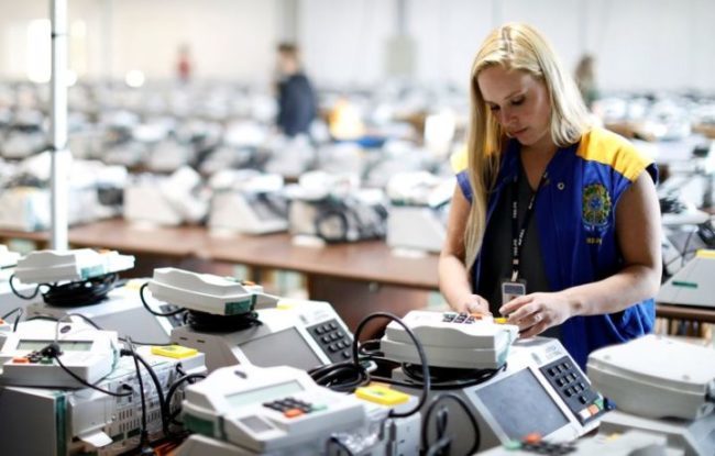Funcionária da Justiça Eleitoral prepara urna eletrônica para eleição de 2018