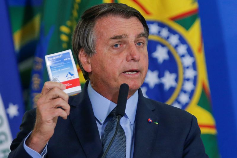 Presidente Jair Bolsonaro segura caixa de cloroquina em cerimônia do Palácio do Planalto