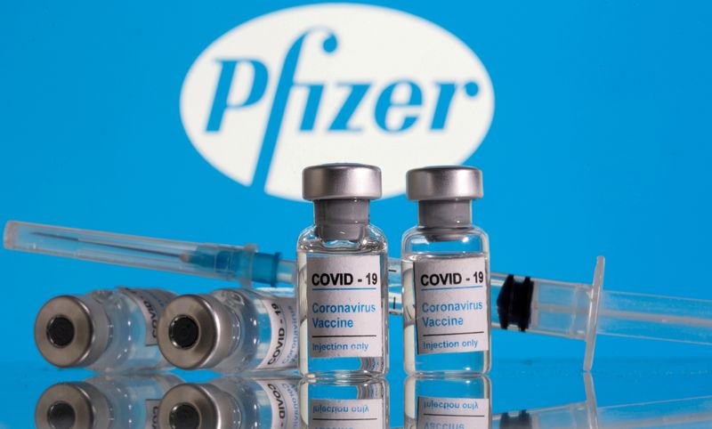 Frascos de vacina contra a Covid-19 em frente ao logo da Pfizer