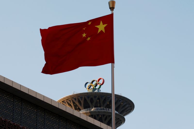 Bandeira da China sobre os anéis olímpicos na Torre Olímpica em Pequim
