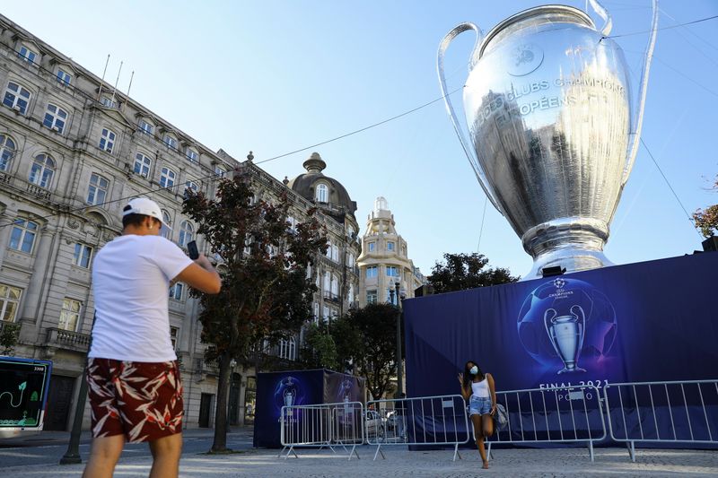 Pessoas tiram fotos de modelo inflável de taça da Champions no Porto, em Portugal