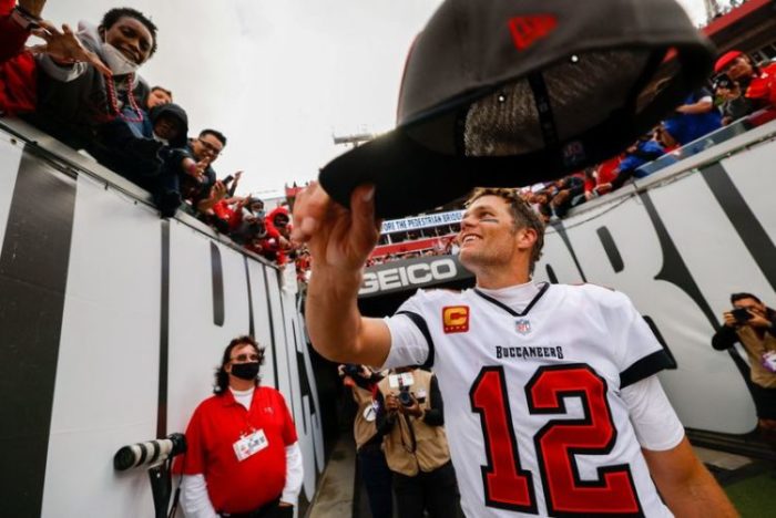 Tom Brady entrega seu boné para um torcedor depois de partida da NFL