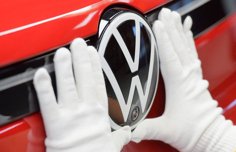 Funcionário coloca logotipo da Volkswagen em um carro, na linha de produção de modelos elétricos do Grupo Volkswagen, em Zwickau