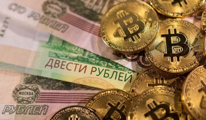 Notas de rublo russo ao lado de representações de bitcoin