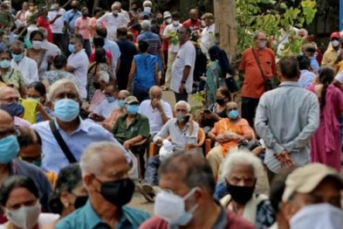 Pessoas com máscaras de proteção esperam para receber vacina contra Covid-19 em centro de vacinação em Mumbai, na Índia