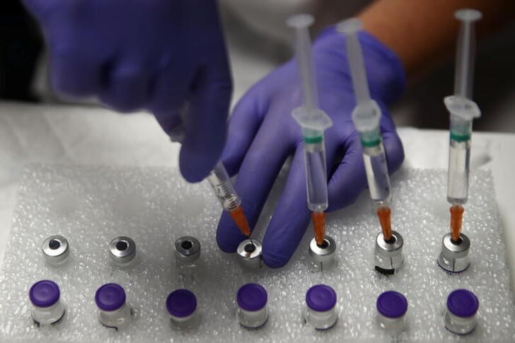Agente de saúde usa solução salina para preparar doses da vacina "Comirnaty" da Pfizer-BioNTech contra a Covid-19 em centro de vacinação em Madri, Espanha