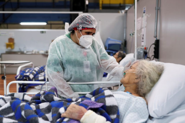 Enfermeira de um hospital em Santo André, no Estado de São Paulo, conversa com paciente idosa