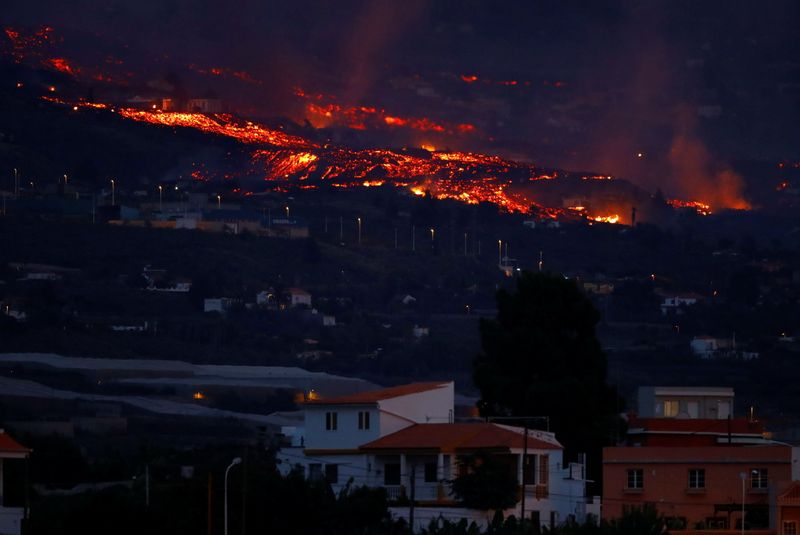 Lava por trás de casas após erupção de vulcão na ilha de La Palma, na Espanha