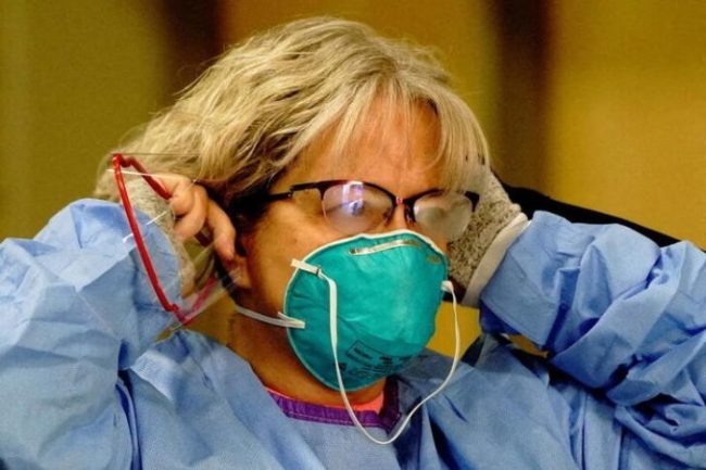 Enfermeira coloca máscara de proteção N95 em centro de testagem de Covid-19 em Bismarck, no Estado norte-americano de Dakota do Norte