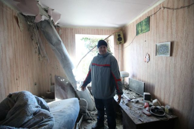 Morador em apartamento atingido por artilharia em Kharkiv