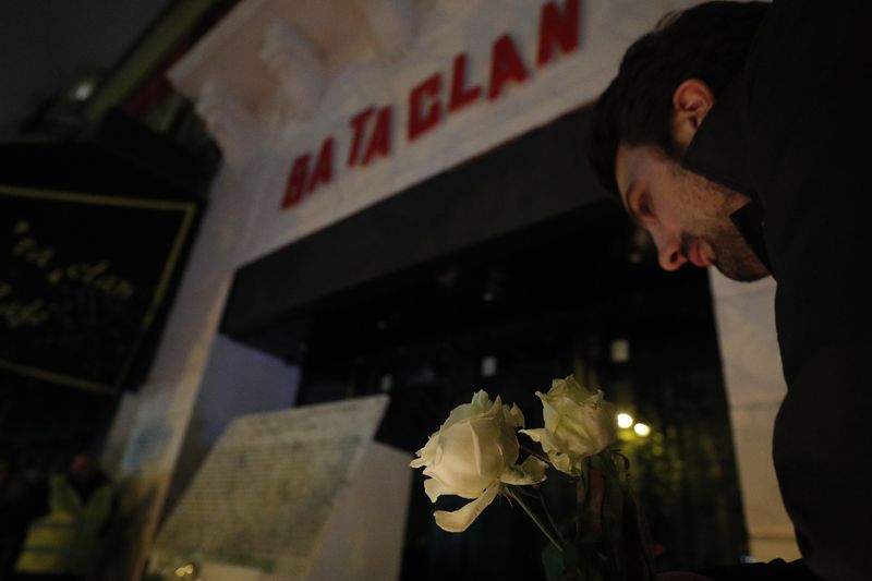 Homem deposita flores em frente ao Bataclan, um dos locais atacados por militantes islâmicos em 2015, em Paris